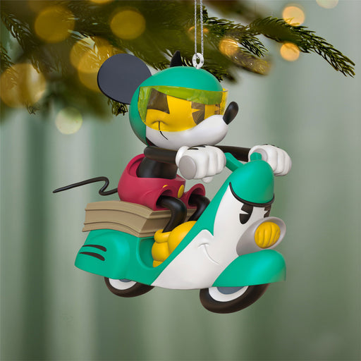 Decorative ornament of a character on a scooter with a blurred Christmas tree background