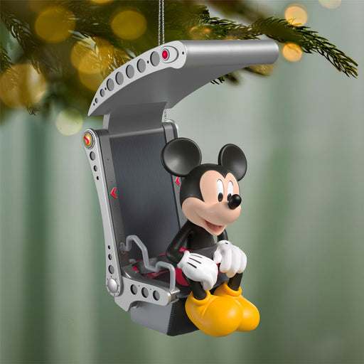 Mickey Mouse Christmas ornament in a camera lens on a tree branch with blurred lights in the background