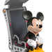 Mickey Mouse figure sitting on a gaming chair with a white background