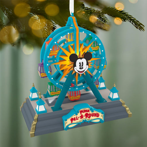 Decorative Christmas ornament resembling a Ferris wheel with Mickey Mouse face, hanging on a tree.