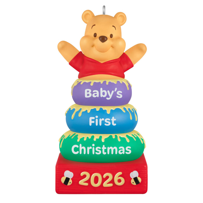 Decorative ornament with Winnie the Pooh for 'Baby's First Christmas 2026' on a white background