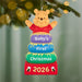 Decorative ornament with Winnie the Pooh for 'Baby's First Christmas 2026' on a tree.