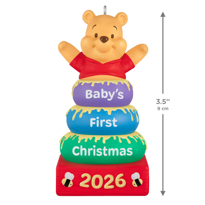 Decorative ornament with Winnie the Pooh for 'Baby's First Christmas 2026' on a white background