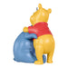 Yellow bear character hugging a blue object on a white background