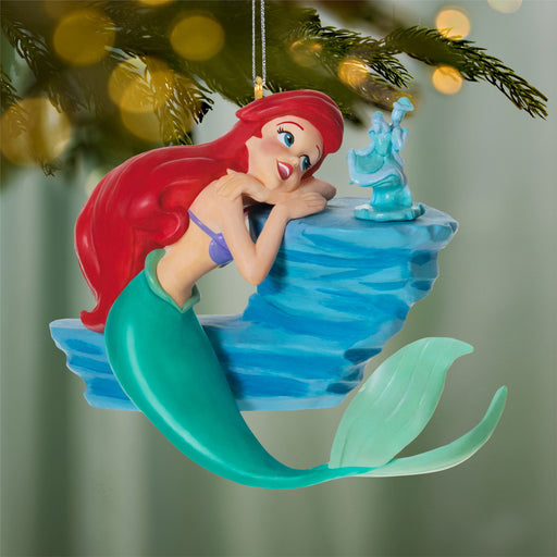 Mermaid ornament on a Christmas tree with blurred lights in the background