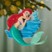 Mermaid ornament on a Christmas tree with blurred lights in the background