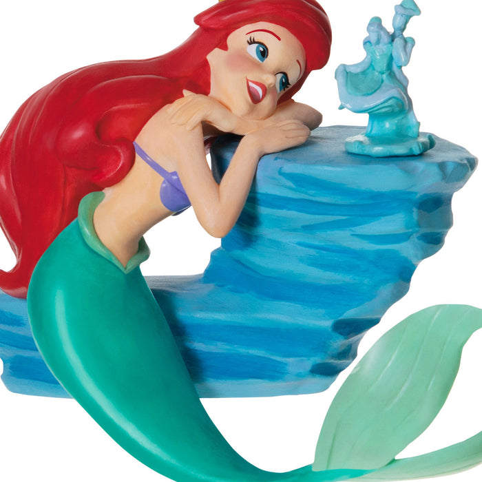 Mermaid figurine with red hair and green tail on a blue platform