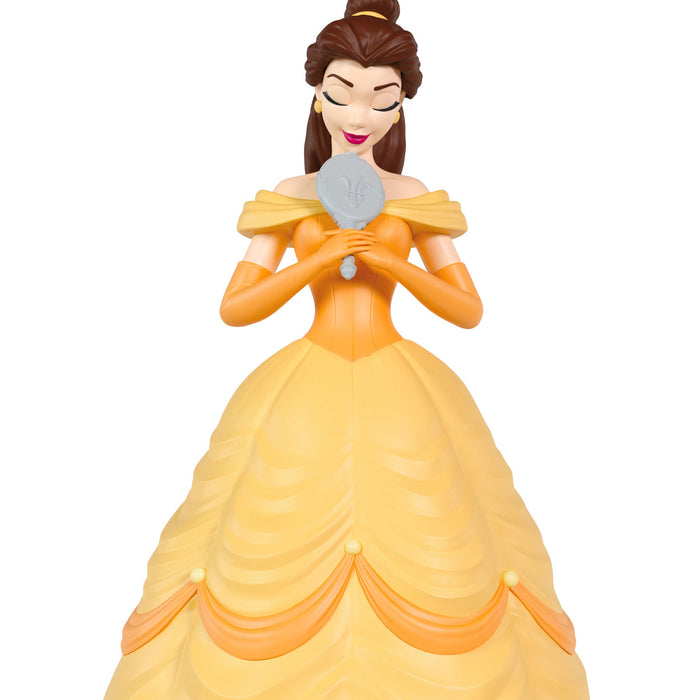 Figurine of a character in a yellow dress holding a gray object on a white background