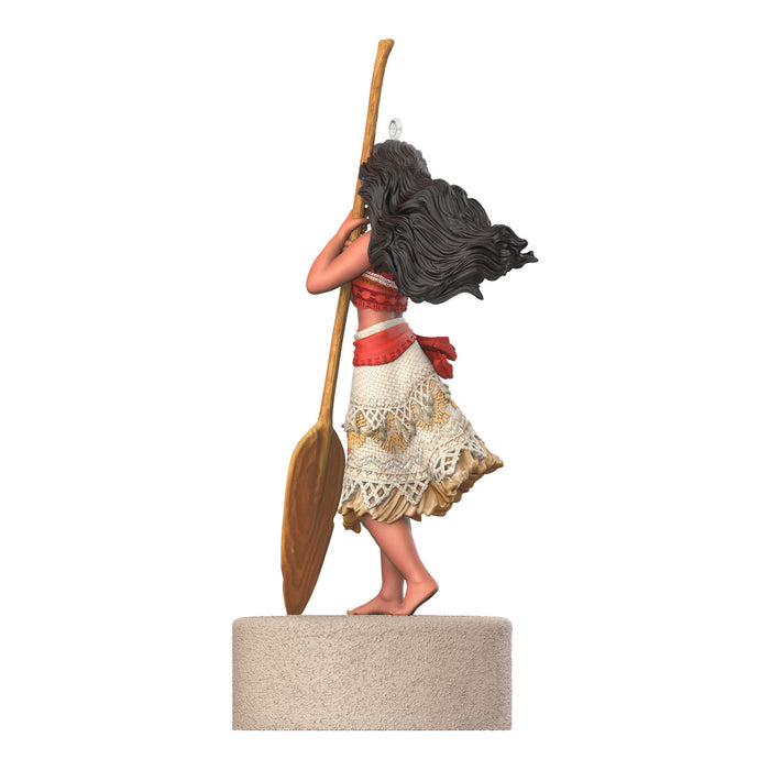 Statue of a woman with long hair and a red top holding a wooden paddle on a white background