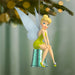 Tinker Bell fairy ornament sitting on a silver thimble with blurred Christmas tree lights in the background.