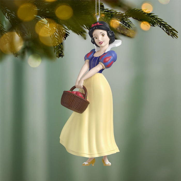 Snow White ornament holding a basket on a blurred green background