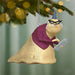 Decorative ornament of a sloth wearing glasses and a sweater, hanging from a Christmas tree.