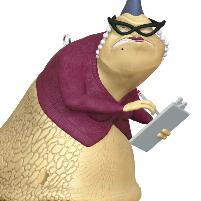 Slug-like character wearing a purple sweater and glasses, holding a clipboard.