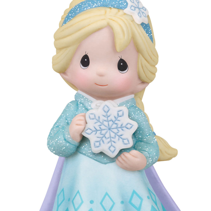 Figurine of a girl in a blue winter outfit holding a snowflake