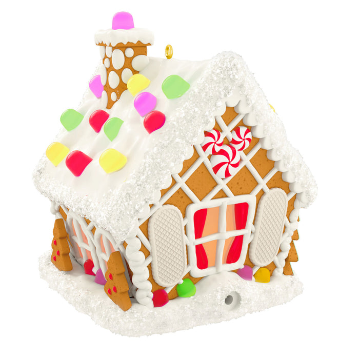 Decorative gingerbread house ornament with colorful icing on a white background