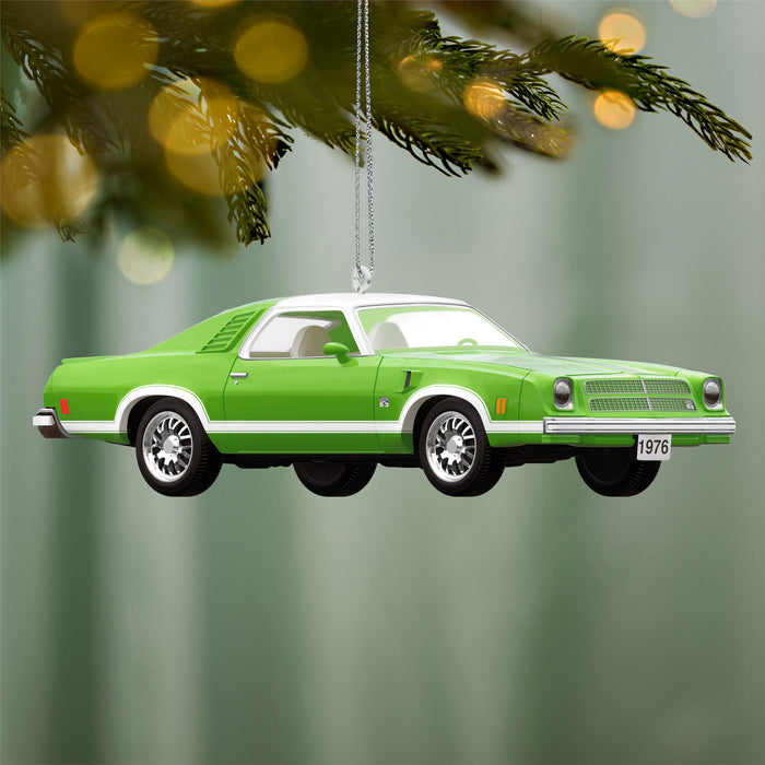Green classic car ornament hanging against a blurred green background with lights