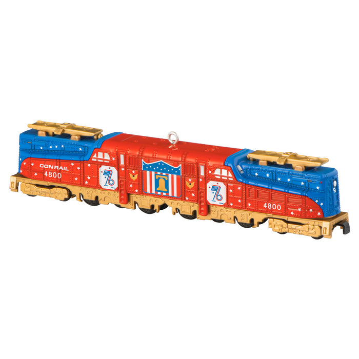Model train engine with red, blue, and gold colors on a white background