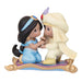 Figurines of a girl and a boy on a magic carpet with a white background