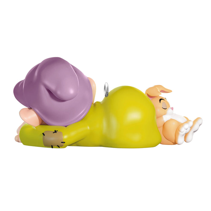 Toy figure of a character in a green outfit with a purple hat, lying on its side.