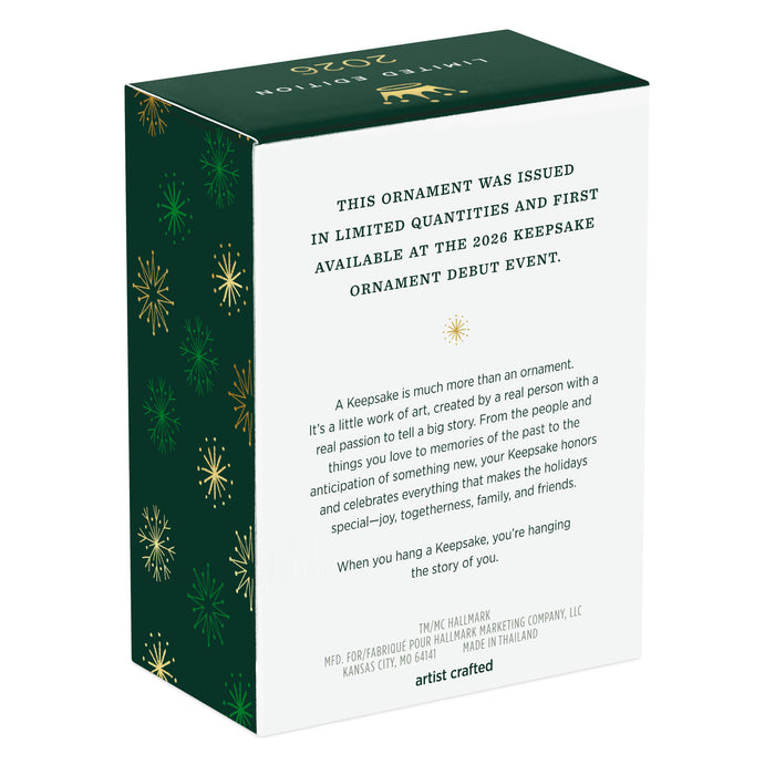 Box packaging for a keepsake ornament with green and gold decorative elements.