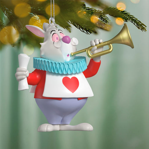 Decorative ornament of a cartoon rabbit character with a trumpet, hanging from a Christmas tree.