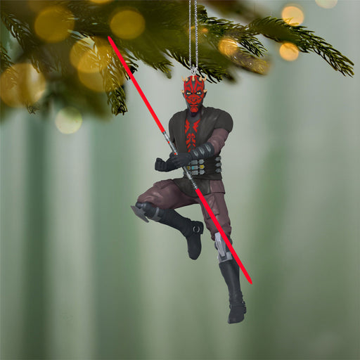 Decorative ornament of a character with red lightsabers hanging from a Christmas tree.
