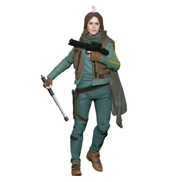 Action figure in a green and brown outfit holding weapons on a white background