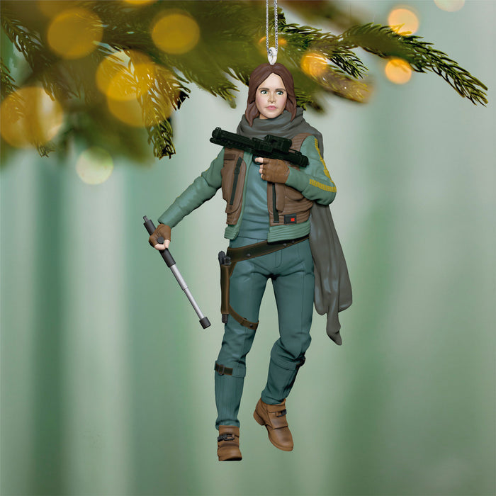 Hanging ornament of a character in green outfit with weapons, against a blurred green background