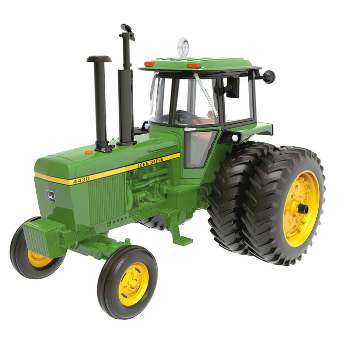 Model green tractor with yellow wheels on a white background