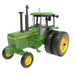 Model green tractor with yellow wheels on a white background