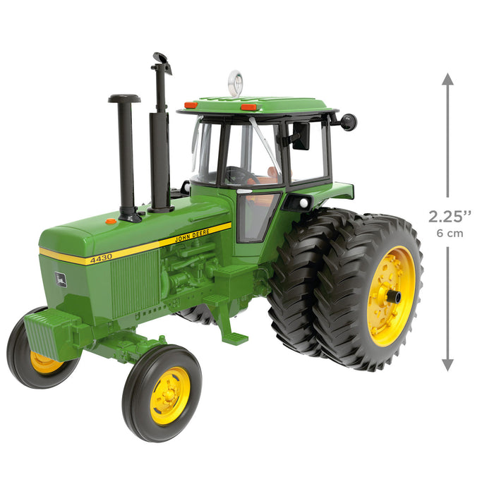 Model of a green tractor with yellow wheels on a white background