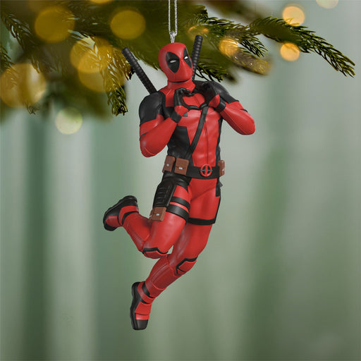 Deadpool Christmas ornament hanging on a tree with blurred lights in the background