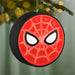Spider-Man themed ornament hanging on a Christmas tree.