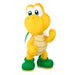 Toy figure of a yellow turtle with green boots on a white background
