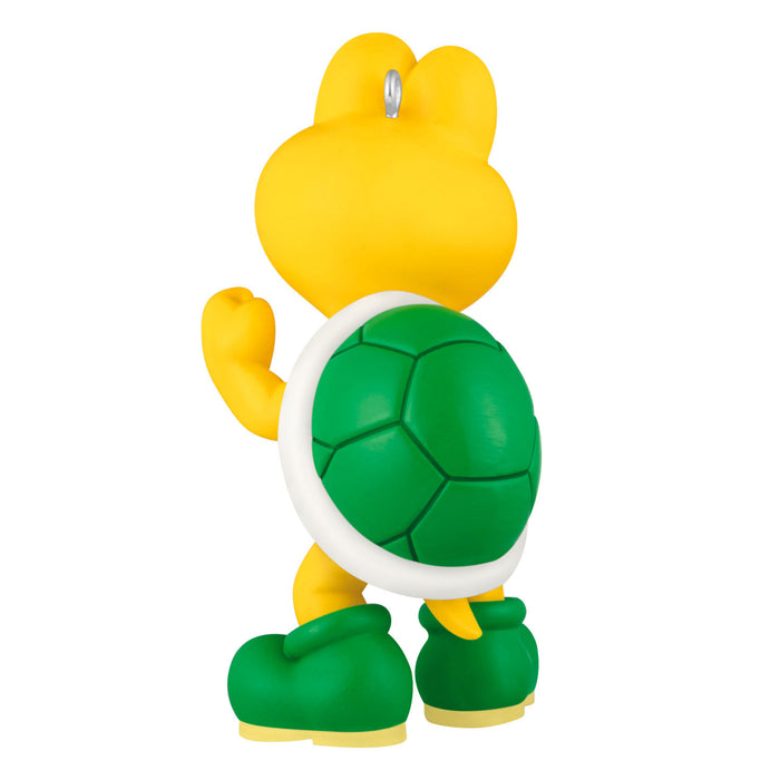 Toy figure of a character with a yellow head and green shell on a white background