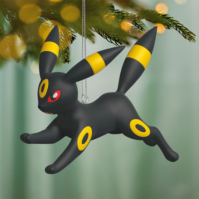 Black and yellow Umbreon Pokémon ornament hanging on a Christmas tree.