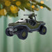 Decorative vehicle ornament hanging on a Christmas tree with a green background.