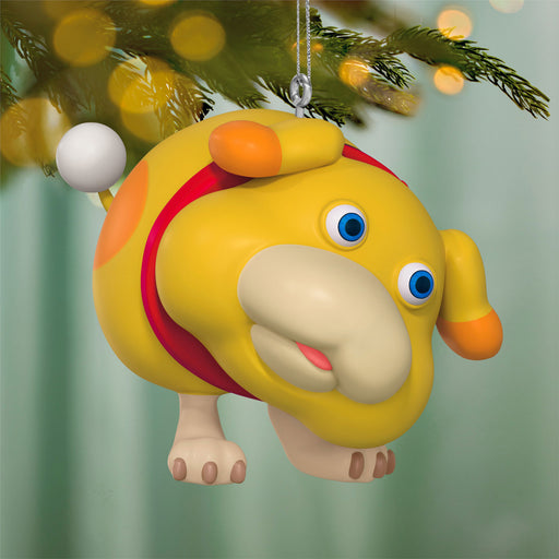 Colorful cartoon figure ornament hanging on a Christmas tree with blurred lights in the background
