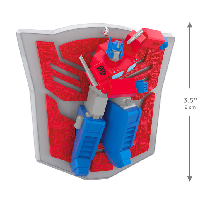 Toy figure of a robot on a shield with red and blue design, size indicated.