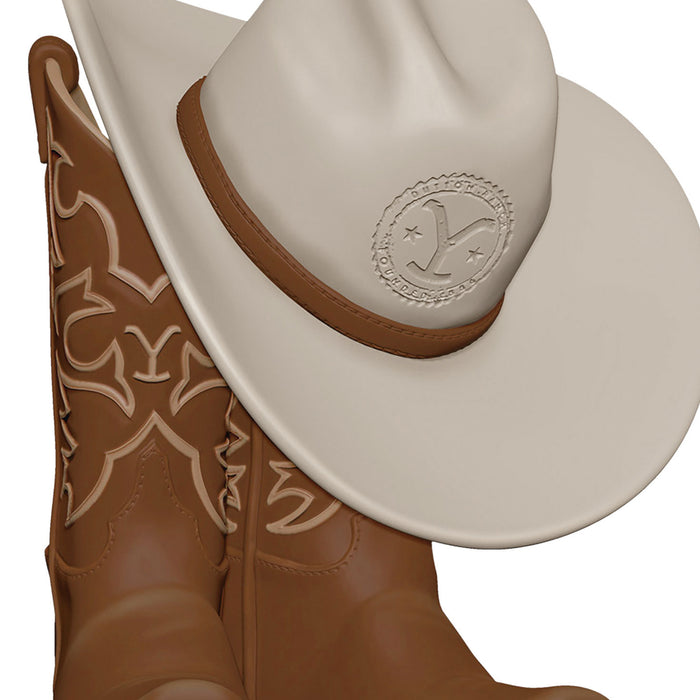 Brown cowboy boot with intricate white patterns and a beige cowboy hat on a white background