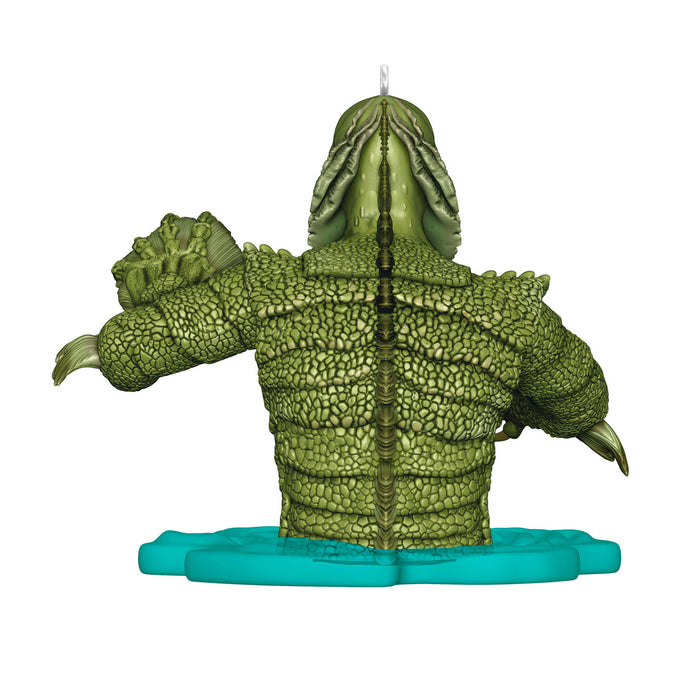 Green lizard-like candle with a blue base on a white background
