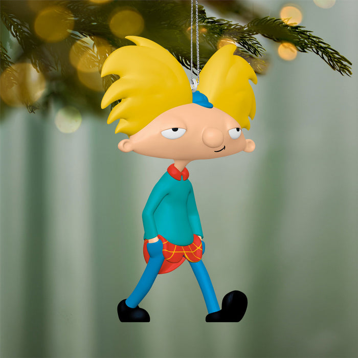 Cartoon character ornament with yellow hair and blue outfit hanging on a Christmas tree.