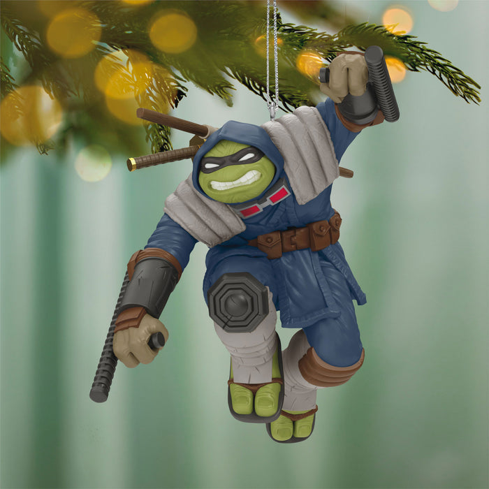 Decorative ornament of a character in a blue outfit with a green face, hanging from a Christmas tree.