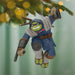 Decorative ornament of a character in a blue outfit with a green face, hanging from a Christmas tree.
