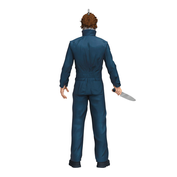 Action figure in blue jumpsuit holding a knife on a white background