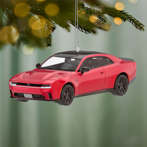 Red car ornament hanging from a Christmas tree with a green background