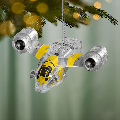 Star Wars X-wing model ornament hanging on a Christmas tree with a blurred green background.