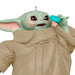 Baby Yoda figurine from 'The Mandalorian' holding a blue cup on a white background