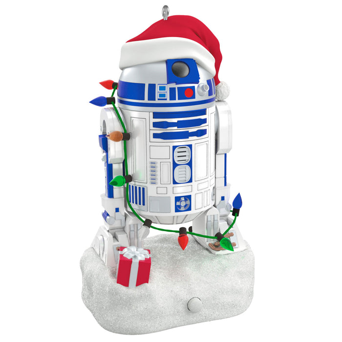 Christmas ornament of R2-D2 from Star Wars with a Santa hat, lights, and presents on a white background.