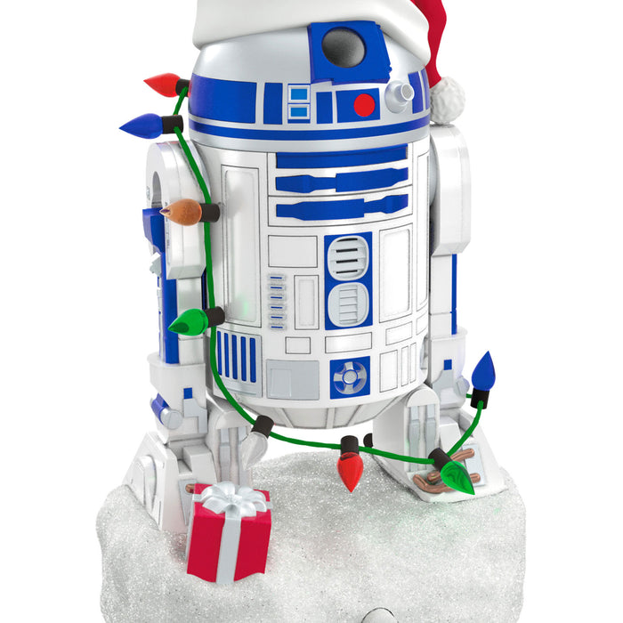 Christmas-themed R2-D2 figurine from Star Wars with lights and a gift.